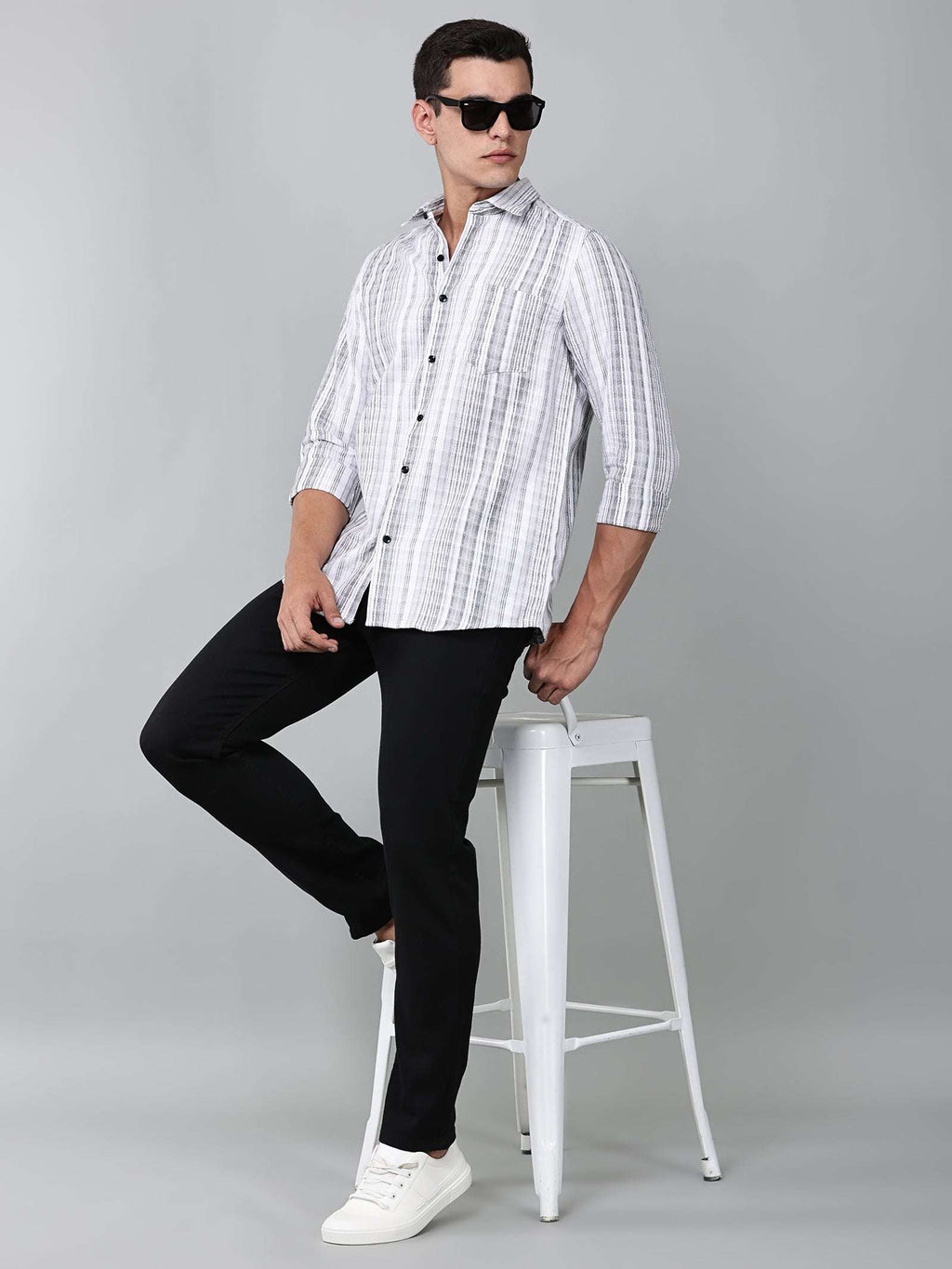 model wearing a white and charcoal textured stripe shirt with black trousers