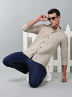 a model wearing a linear drift sketch beige shirt with blue jeans and white sneakers