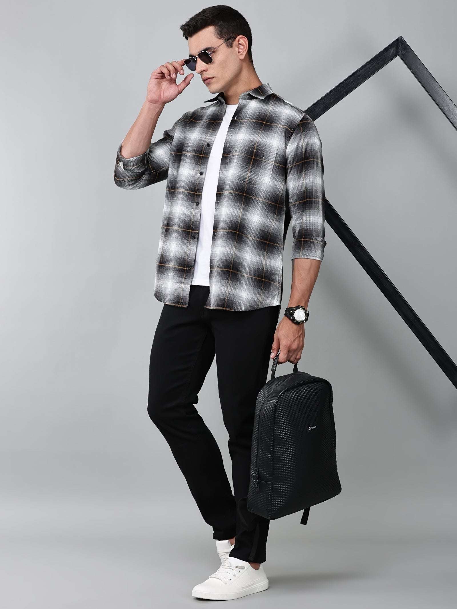 a model wearing a graphite gradient checkered shirt with black trousers