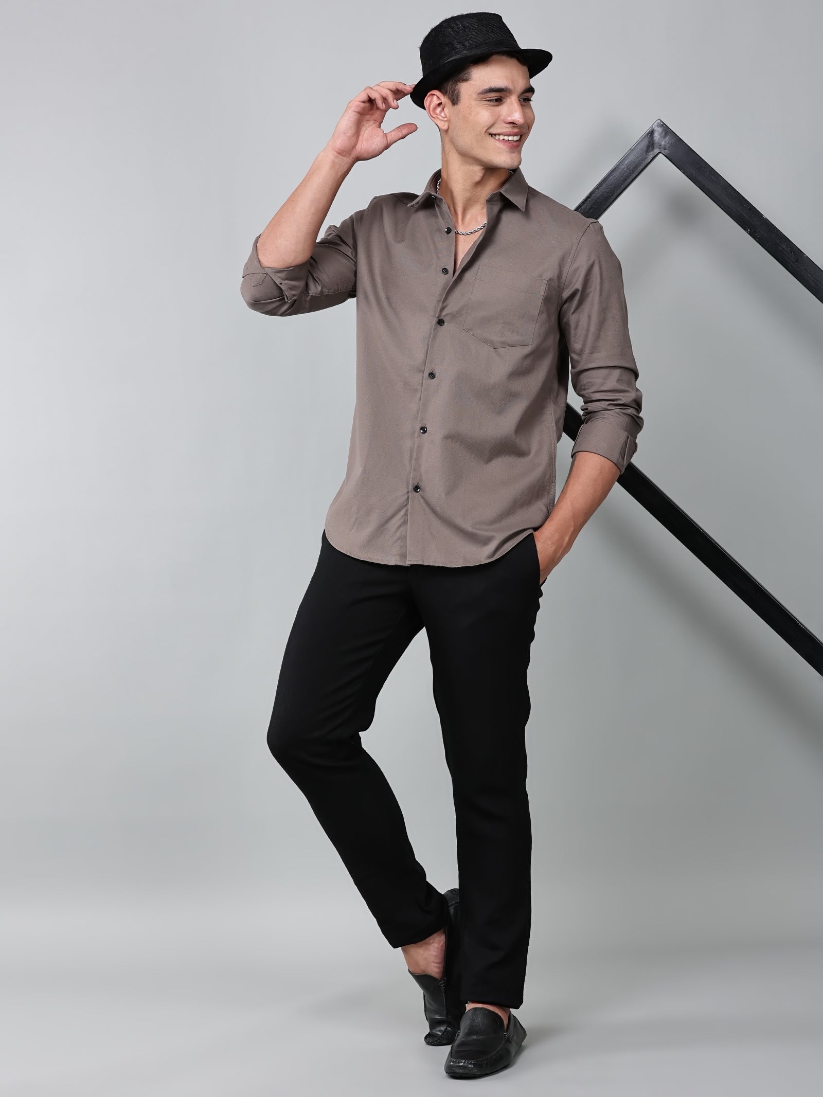 a model wearing a contour textured smoky mauve shirt with black trousers, black loafers and a black hat