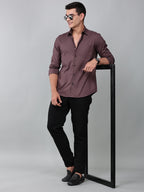 a model wearing a contour textured dusty rose shirt with black trousers and sunglasses