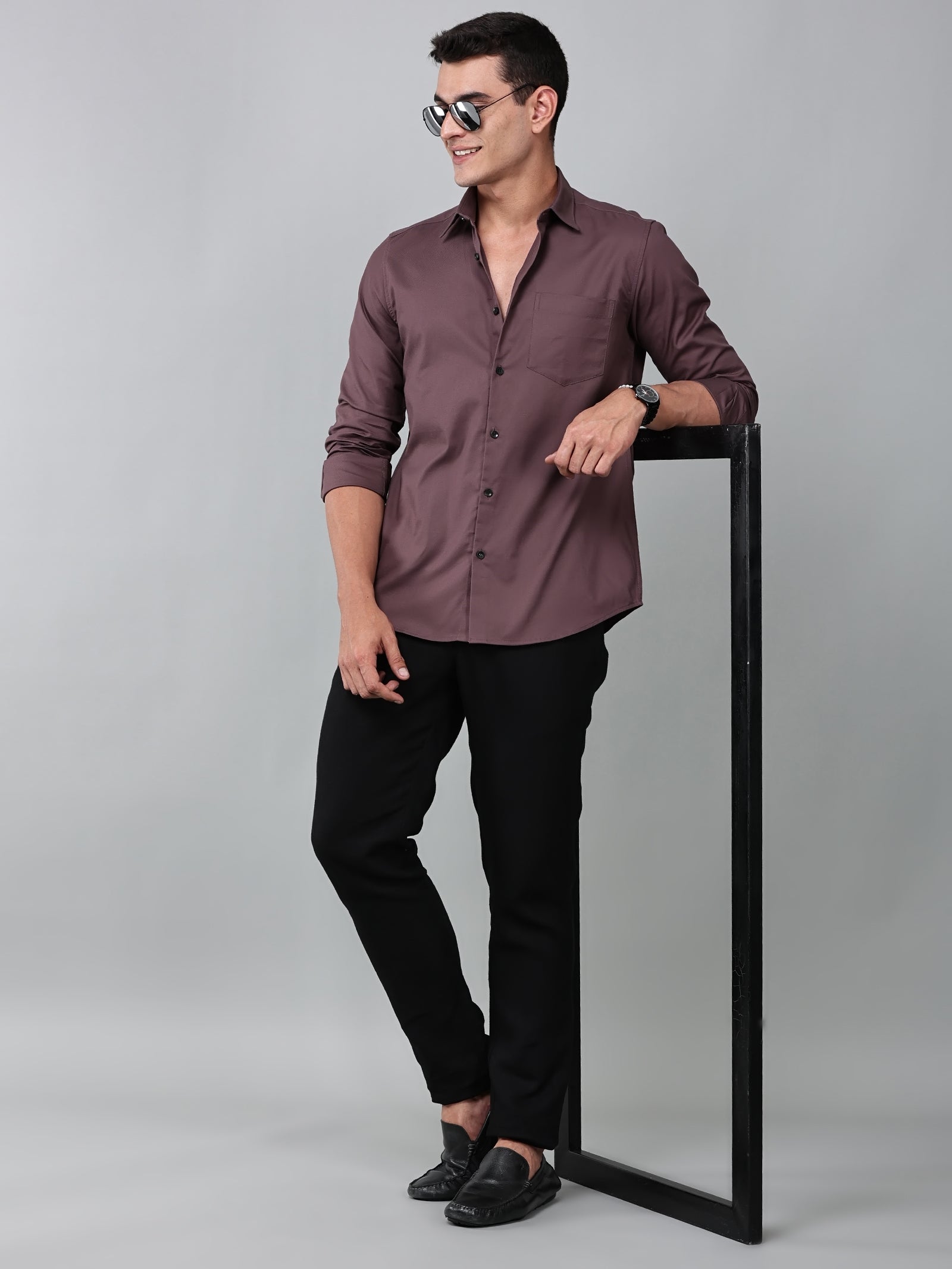a model wearing a contour textured dusty rose shirt with black trousers and sunglasses