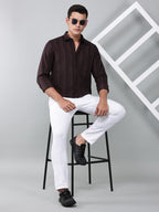 a model wearing a midnight noir (black) maroon shirt with white trousers and black shoes