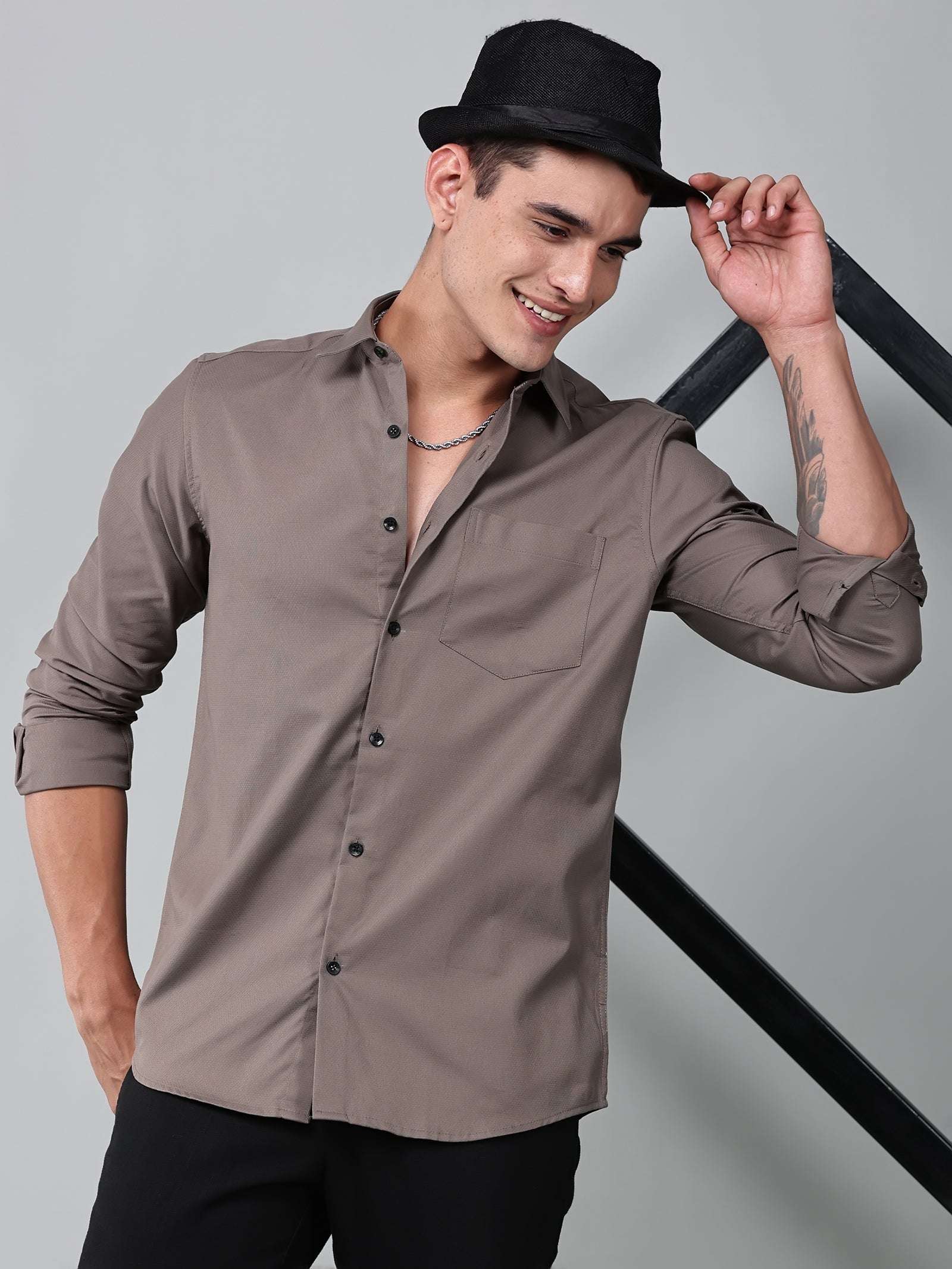 a model wearing a contour textured smoky mauve shirt and a black hat