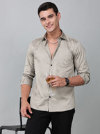 a model wearing a luxe satin ivory stone shirt and holding a glass in one hand