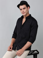 a model wearing a luxe satin black shirt with a black hat