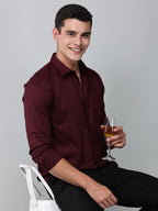 a model wearing a contour textured cherrywood shirt holding a glass in one hand