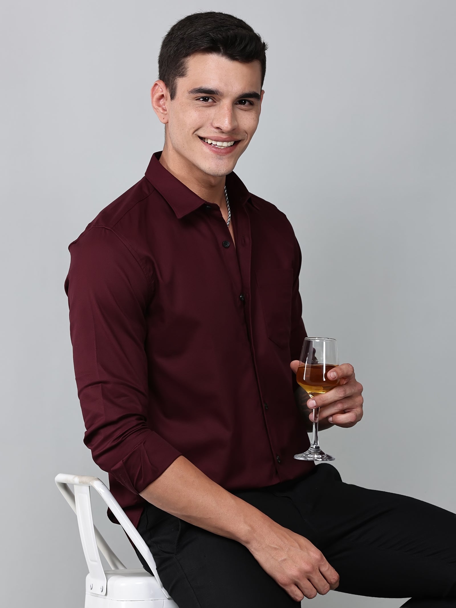 a model wearing a contour textured cherrywood shirt holding a glass in one hand