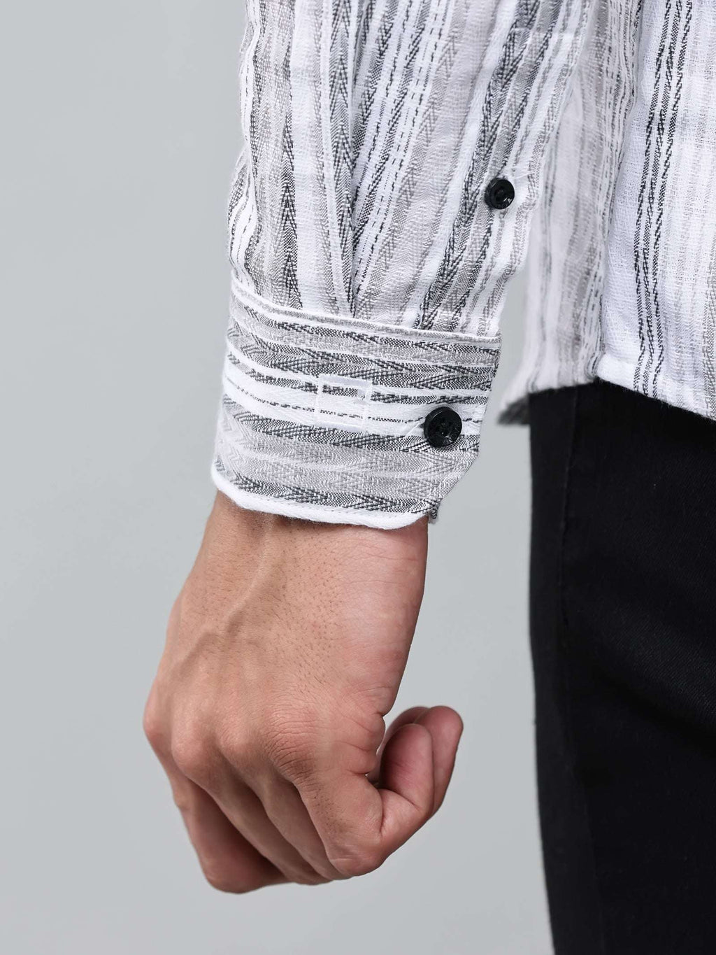 close up shot of the cuff sleeve of the white and charcoal textured stripe shirt