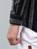 close up shot of the cuff sleeve of the noir (black) echo textured stripe shirt