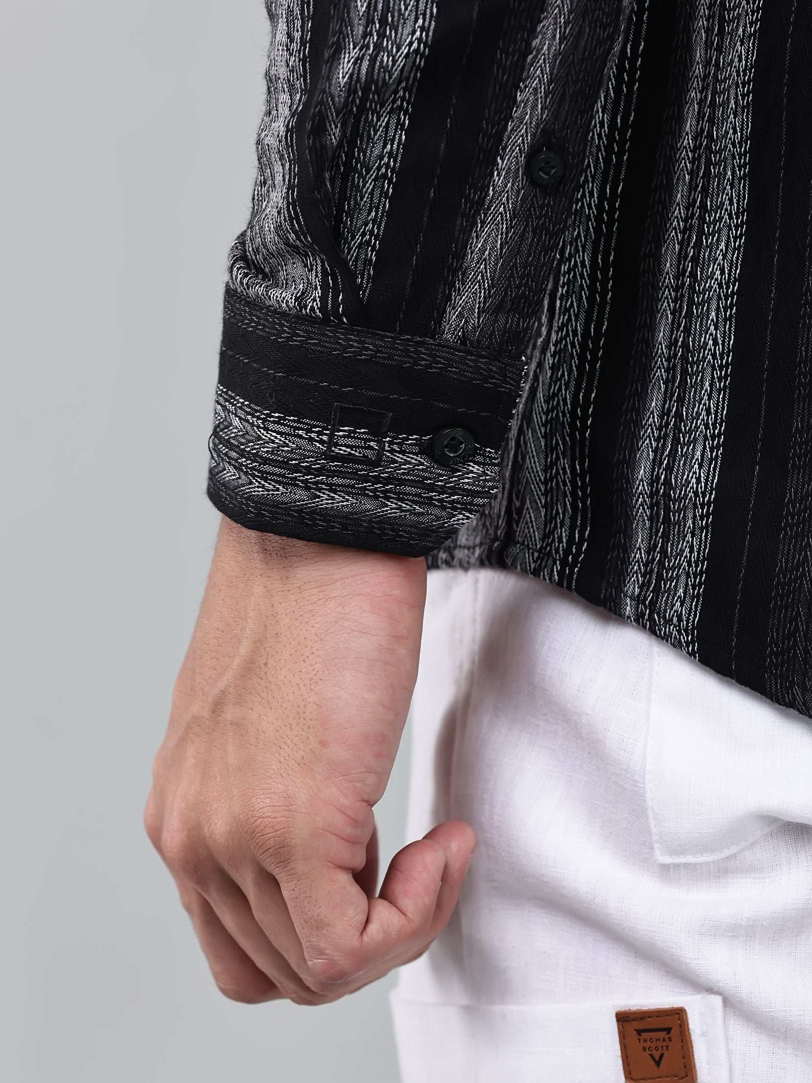 close up shot of the cuff sleeve of the noir (black) echo textured stripe shirt