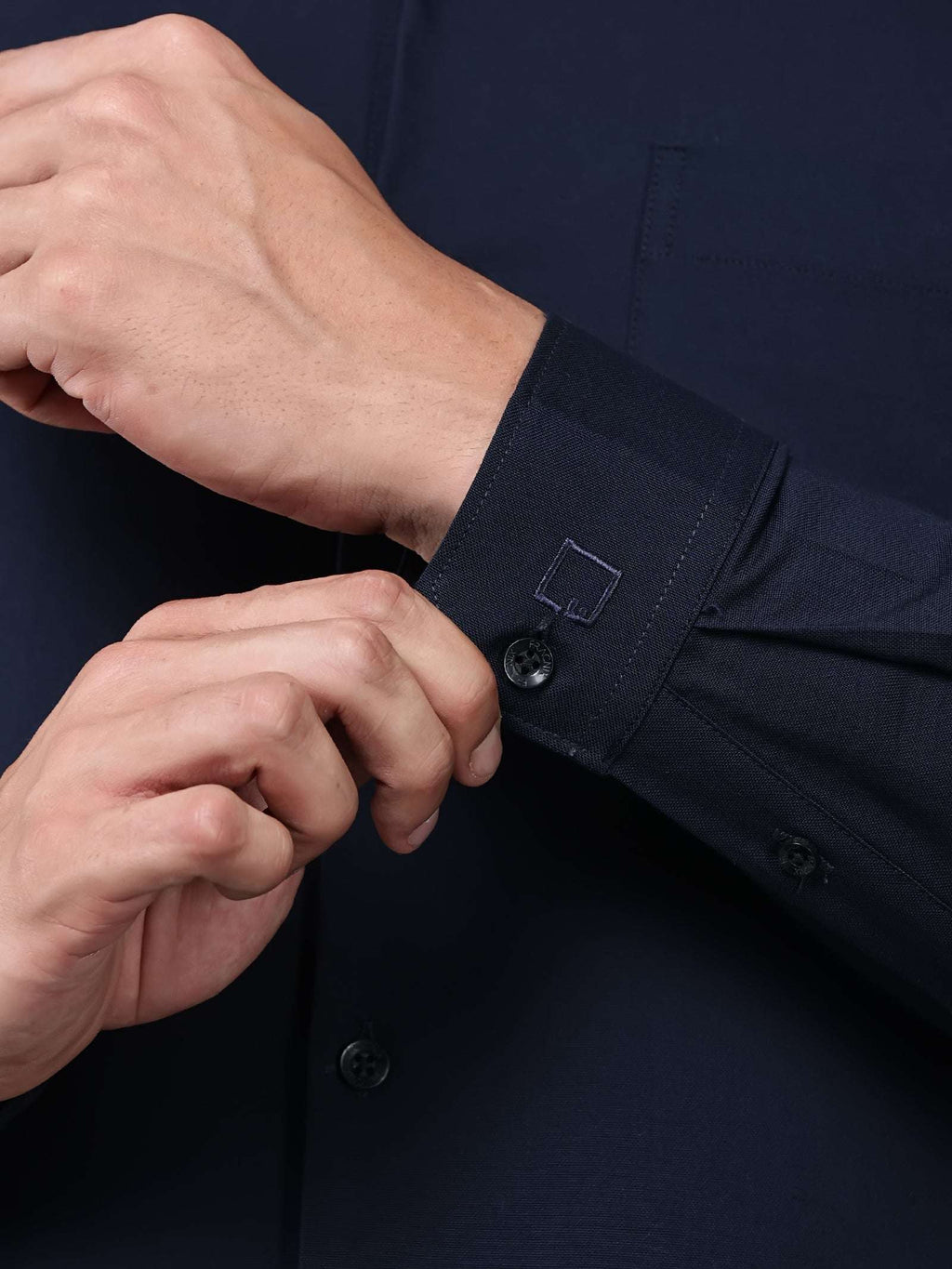 close up shot of the cuff sleeve of the signature textured stretch formal navy blue shirt